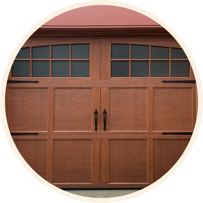 Carriage house garage door with warm wood-look finish, windows and decorative hardware
